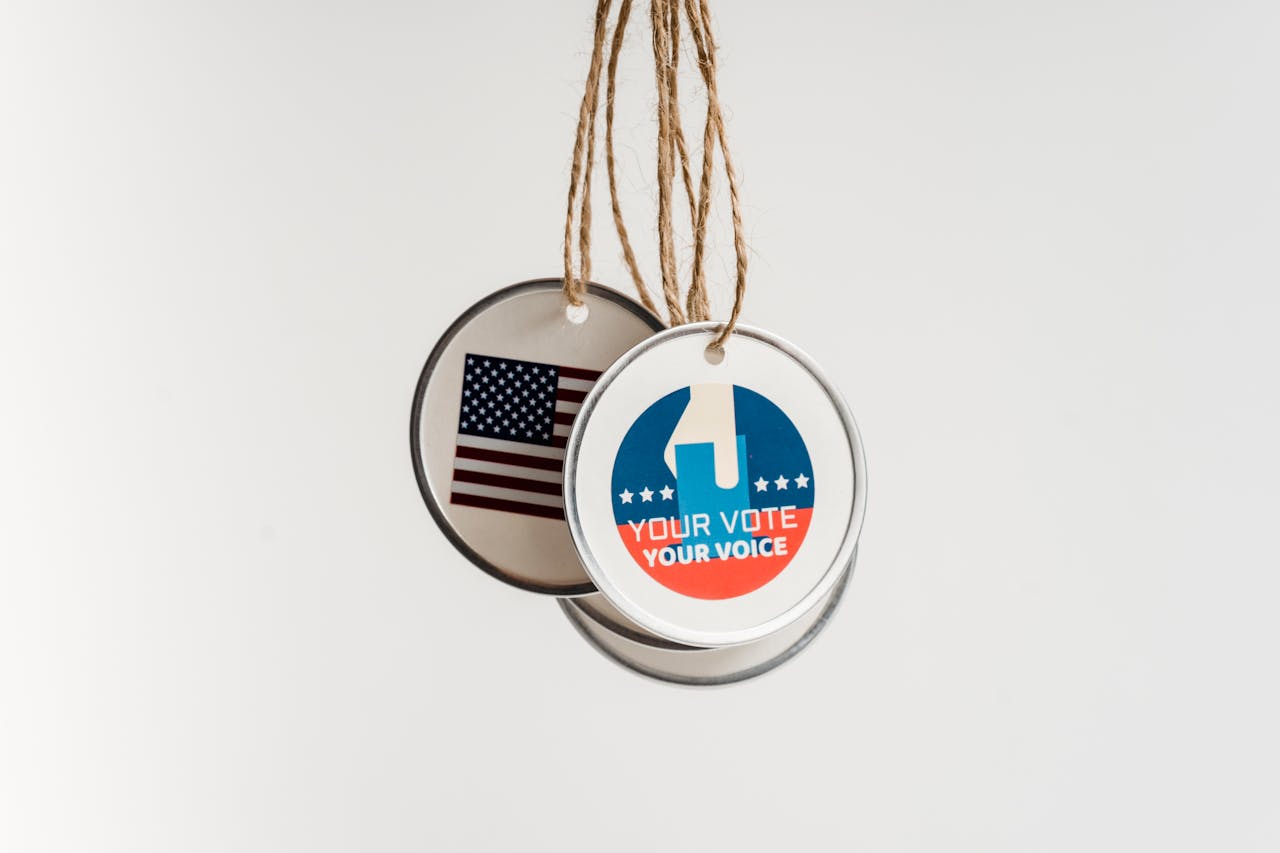 About Close-up view of USA voting badges hanging on strings against a white background.