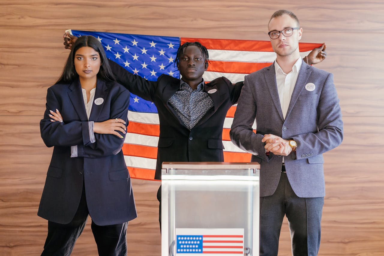 Services A group of diverse individuals standing confidently in front of an American flag at an election podium.