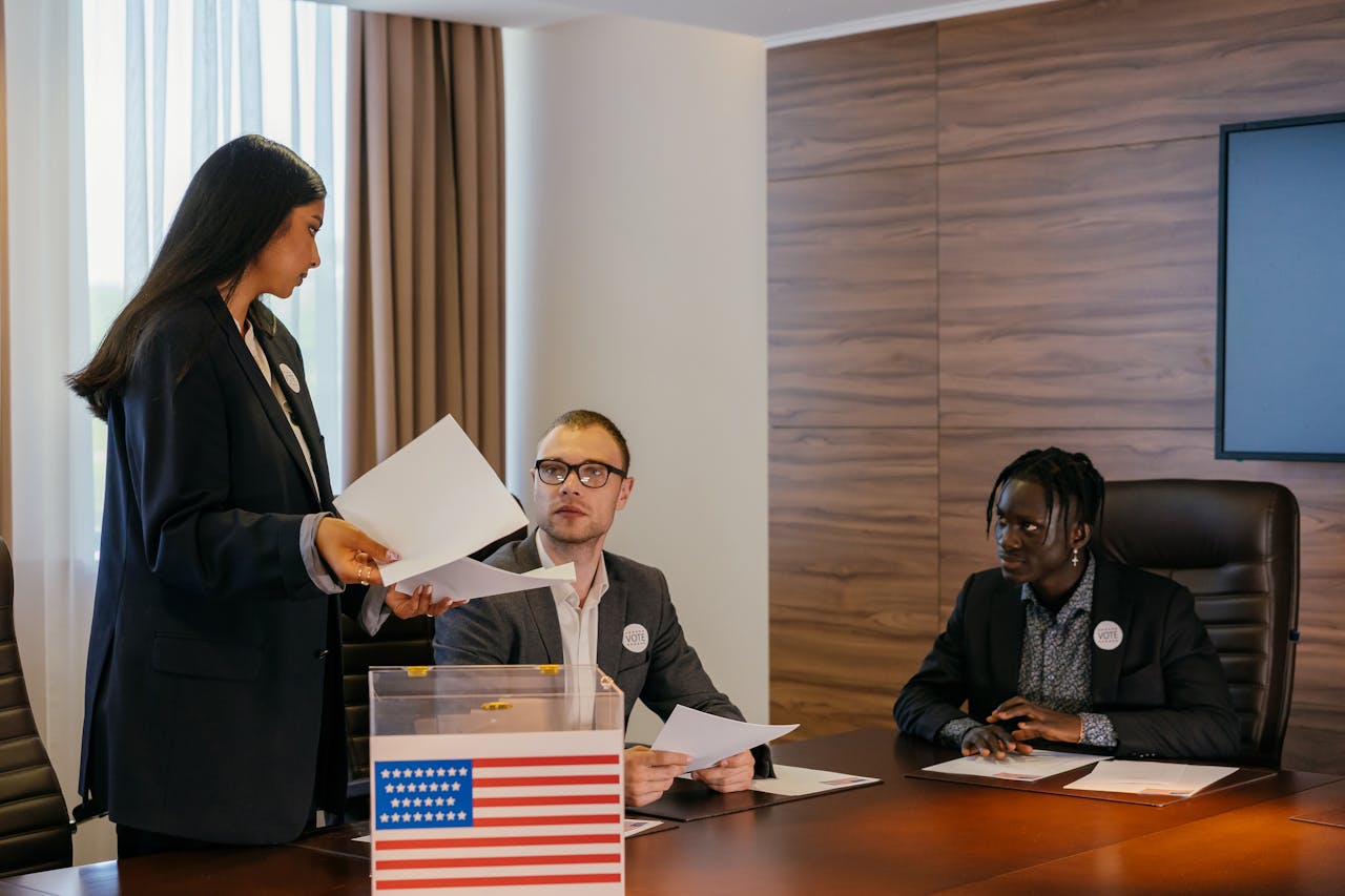 Services A diverse group of professionals deliberating in a conference room about election plans.